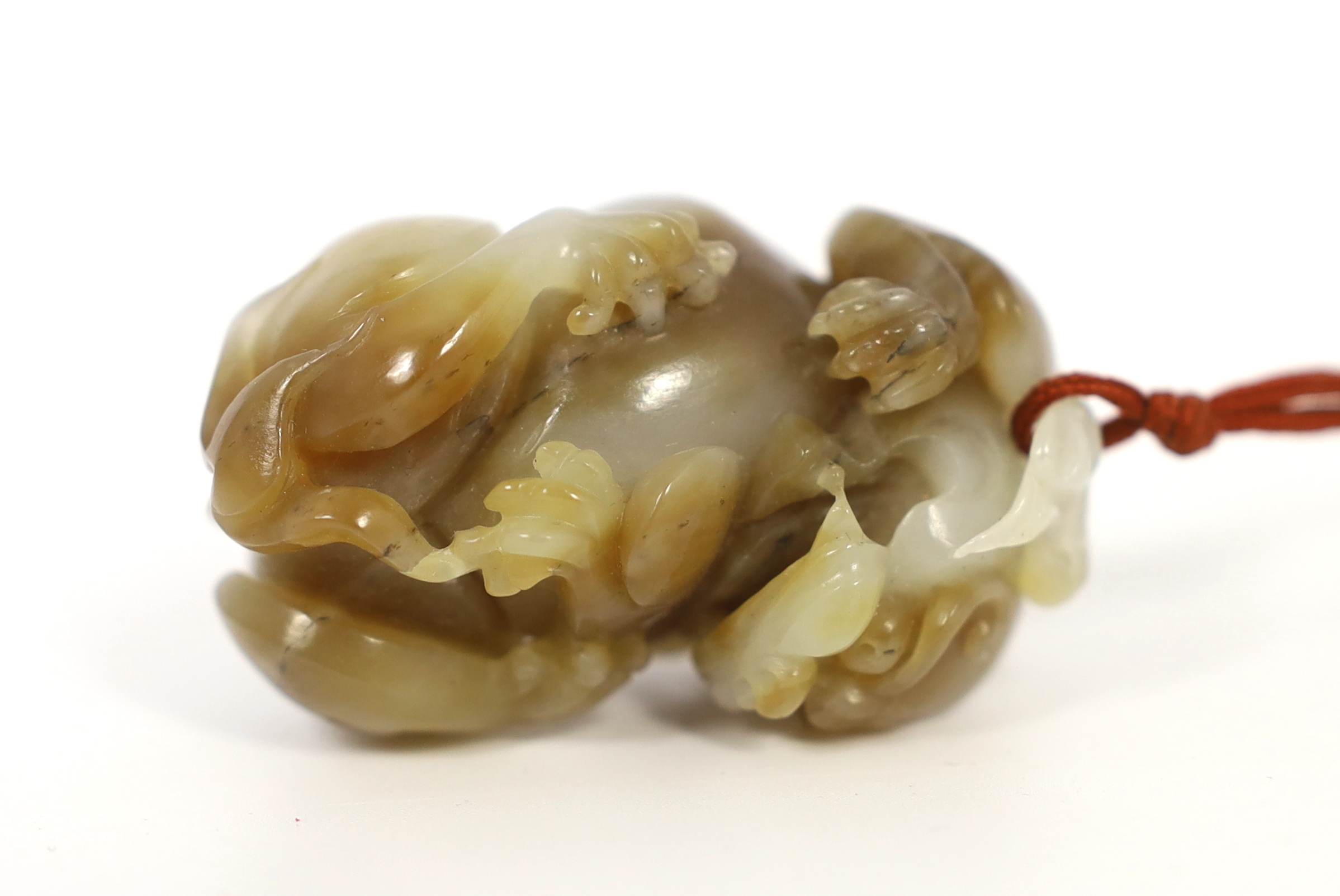 A Chinese white and brown jade lion-dog carving